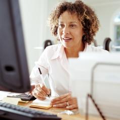 A woman takes notes at her computer