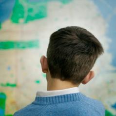 Rear view of a child studying a map