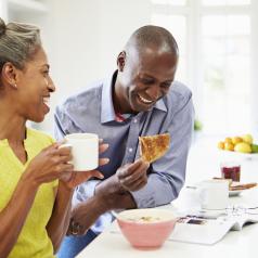 A mature couple laughs over breakfast