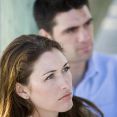 A woman and man gaze off in contemplation