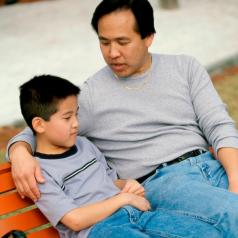 Father and son sitting on a park bench