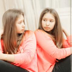 Teenage girl looking at her reflection closeup