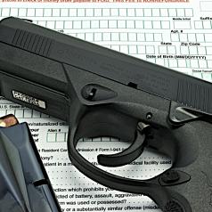 A background check form with a gun