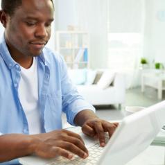 man blogging on laptop