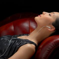 Woman wearing headphones, eyes closed