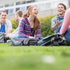 College students laughing together on the grass