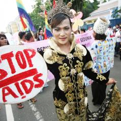 Woman holds a "Stop AIDS" sign at World AIDS Day event