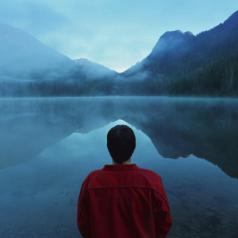 Rear view of person staring out at a lake
