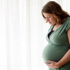 A pregnant woman looks at her belly