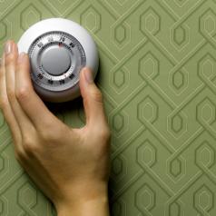 Hand adjusting a wall thermostat