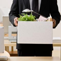 Businessman packing personal desk items in box