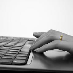 hand with wedding ring on keyboard