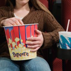 Girl in Movie Theater Eating Popcorn