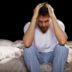 Man sitting up in bed unable to sleep