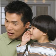 Son whispering into father