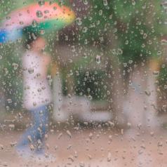Person in rain seen through blurred window