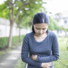 Woman with stomach pain walking in a park