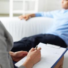 Counselor writes notes on person in treatment