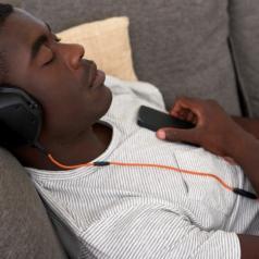 Young man wearing headphones takes a nap