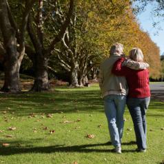 Mature couple walking in park, rear view