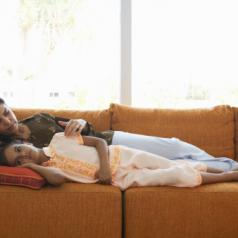 Mother lying on sofa with daughter