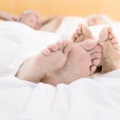 closeup on feet of couple lying in bed