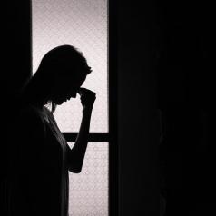 Silhouette of upset woman in open doorway