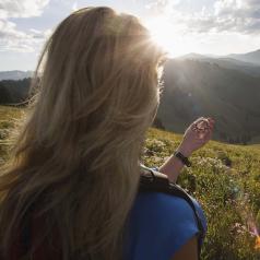 Woman with compass on mountainside