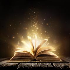 A book lies open on a table. shining lights come out of the pages