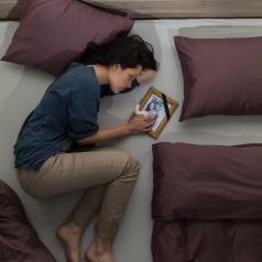 Woman lying in bed with photo of husband
