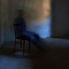 blurry ghostly figure in a chair