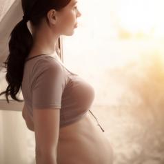 Pregnant woman looking out window