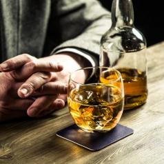 Man sitting at a bar with whiskey