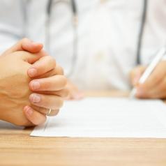 Doctor filling out paperwork with patient