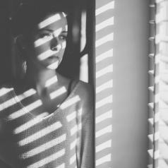 Black and white portrait of woman staring out window