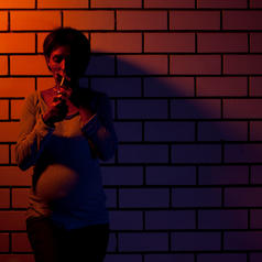 Pregnant woman smoking in an alleyway