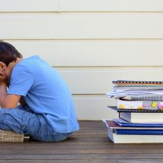 Boy with back to pile of school work