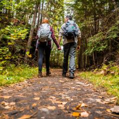 Couple hiking in mountains holds hands and walks together