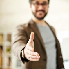 Unfocused photo of person holding out hand to shake