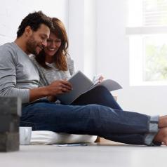 Couple on floor sitting together looking through papers