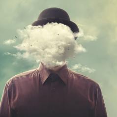 Surreal photo of person in bowler hat with cloud in place of head
