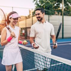 A young couple prepares for a tennis match at dawn.