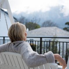 Woman sitting on porch swing, looking at view