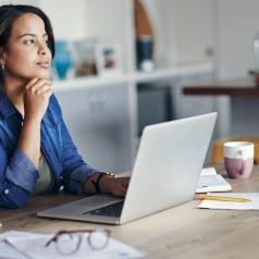 Woman sitting at computer, considering some options