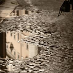 Lower view of professional woman walking on a rainy cobblestone road