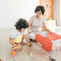Mom and son putting the toys in the box.