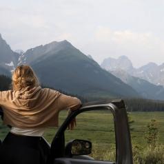 Woman looking at mountains from her car