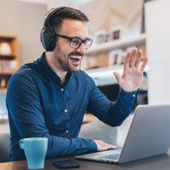 Man waving during online therapy session