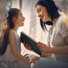 Mother and daughter reading in a blanket fort