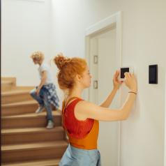 Woman adjusting thermostat
